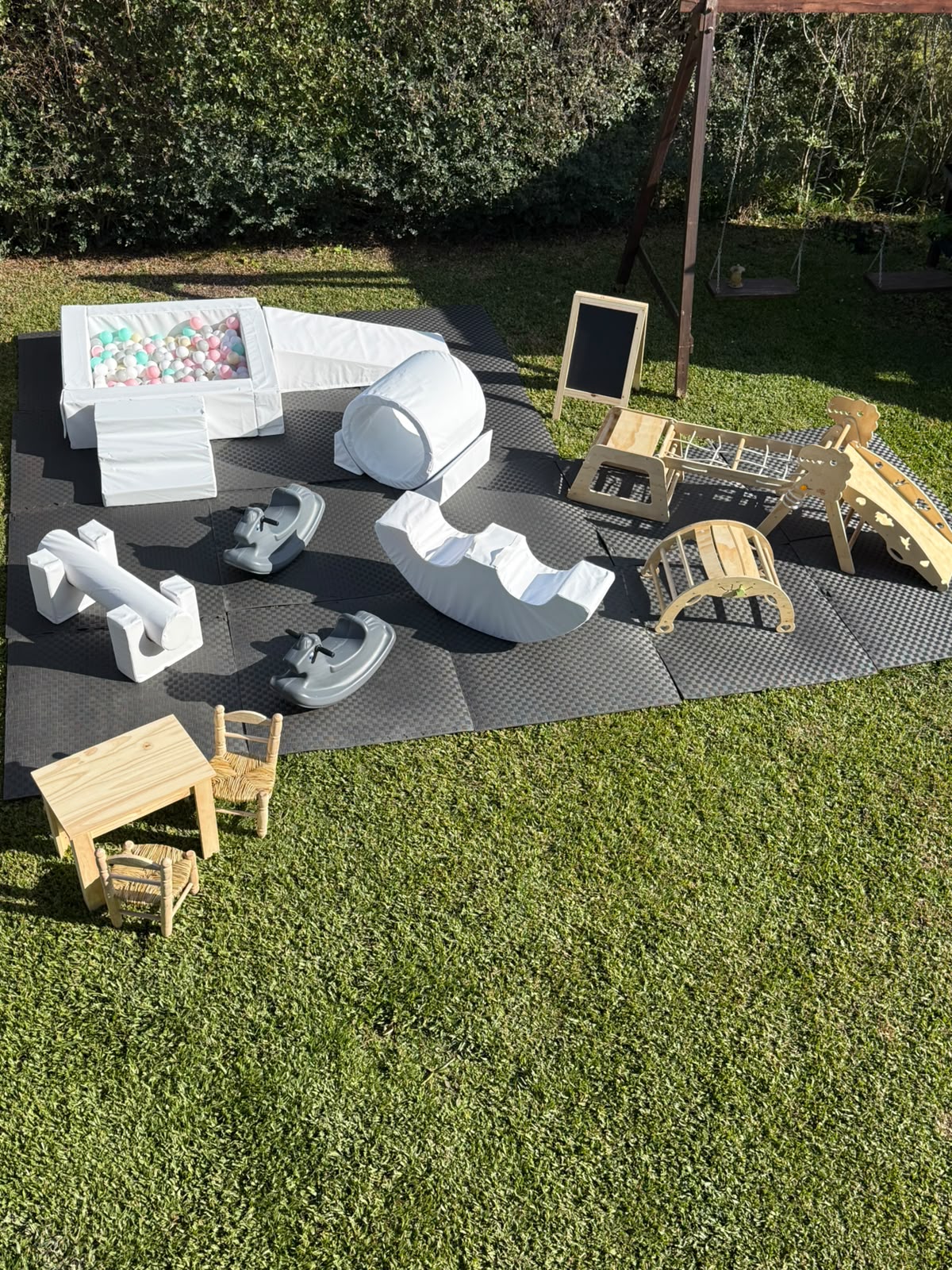 Plaza Soft XL con módulos blancos, pelotero, balancines y circuito de juegos de madera sobre piso encastrable.